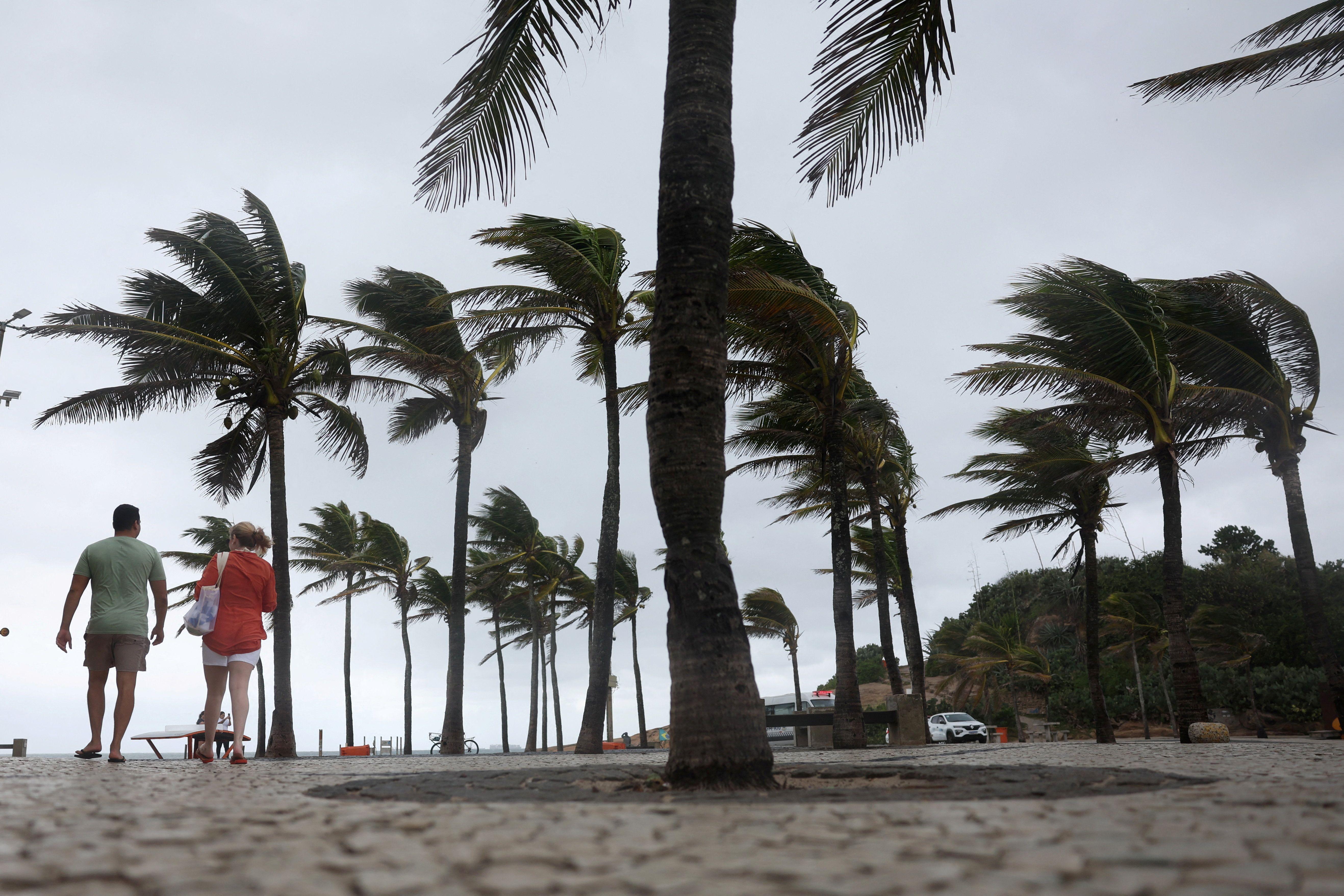 Banhistas andam na praia do Arpoador, no Rio de Janeiro, em meio a ventos fortes 