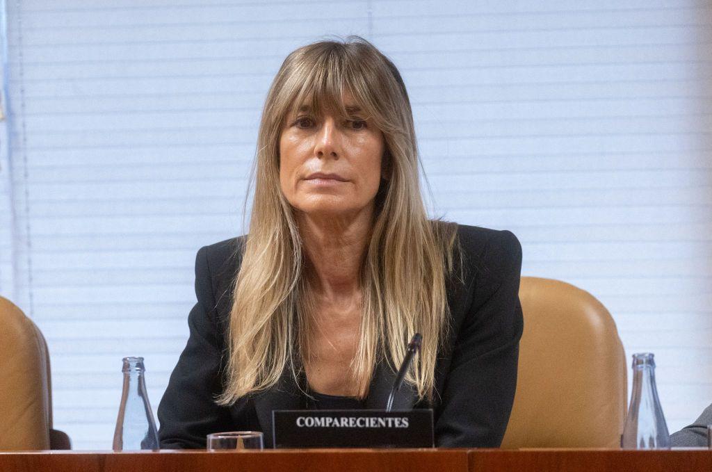 Begoña Gómez, sentada tras un rótulo sobre la mesa con el lema "comparecientes". 