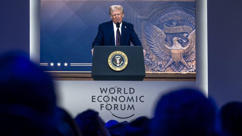 El presidente estadounidense Donald Trump aparece en una gran pantalla durante su intervención por videoconferencia en la reunión anual del Foro Económico Mundial en Davos, el 23 de enero de 2025. 