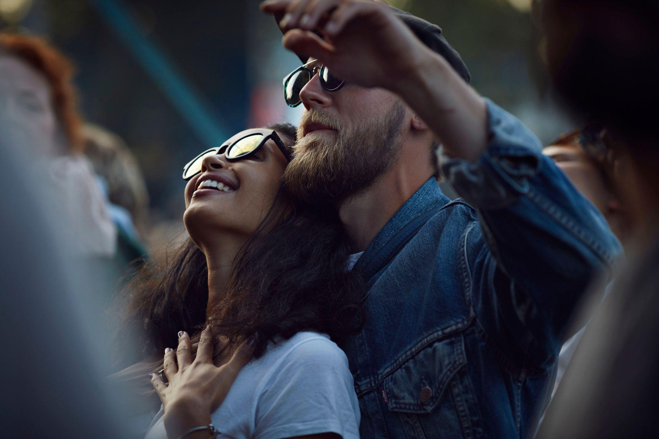 Una mujer y un hombre juntos en un concierto bailando.