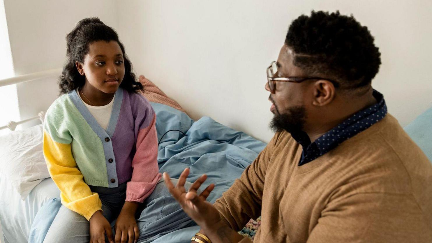 رجل يتحدث إلى طفلة