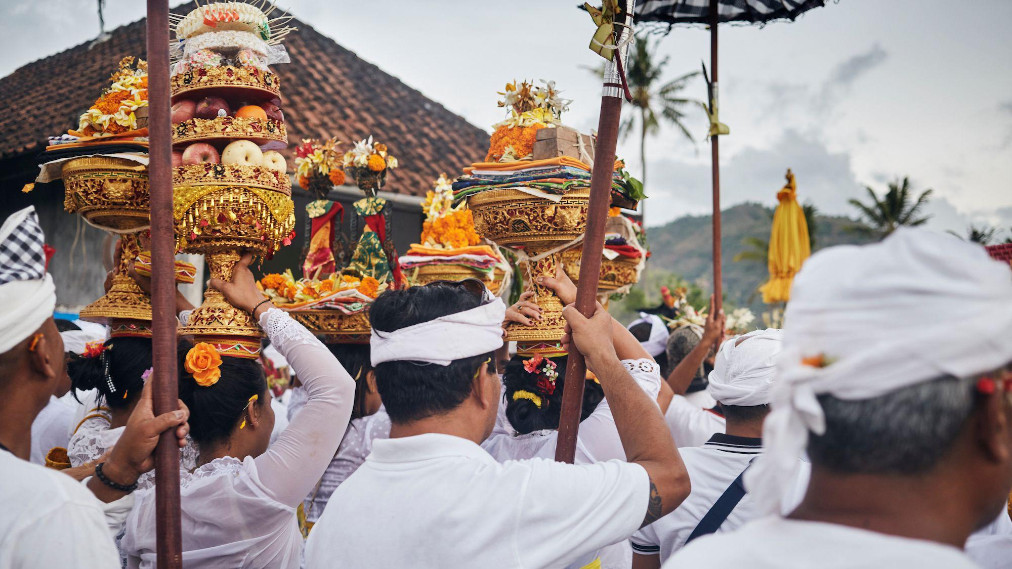 Balinese people walking home with offerings after a Purnama full Moon ceremony in Melasti, Amed.