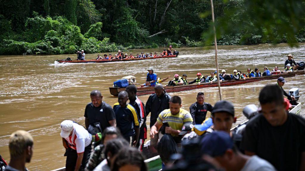 Migrantes em um rio da floresta de Darién