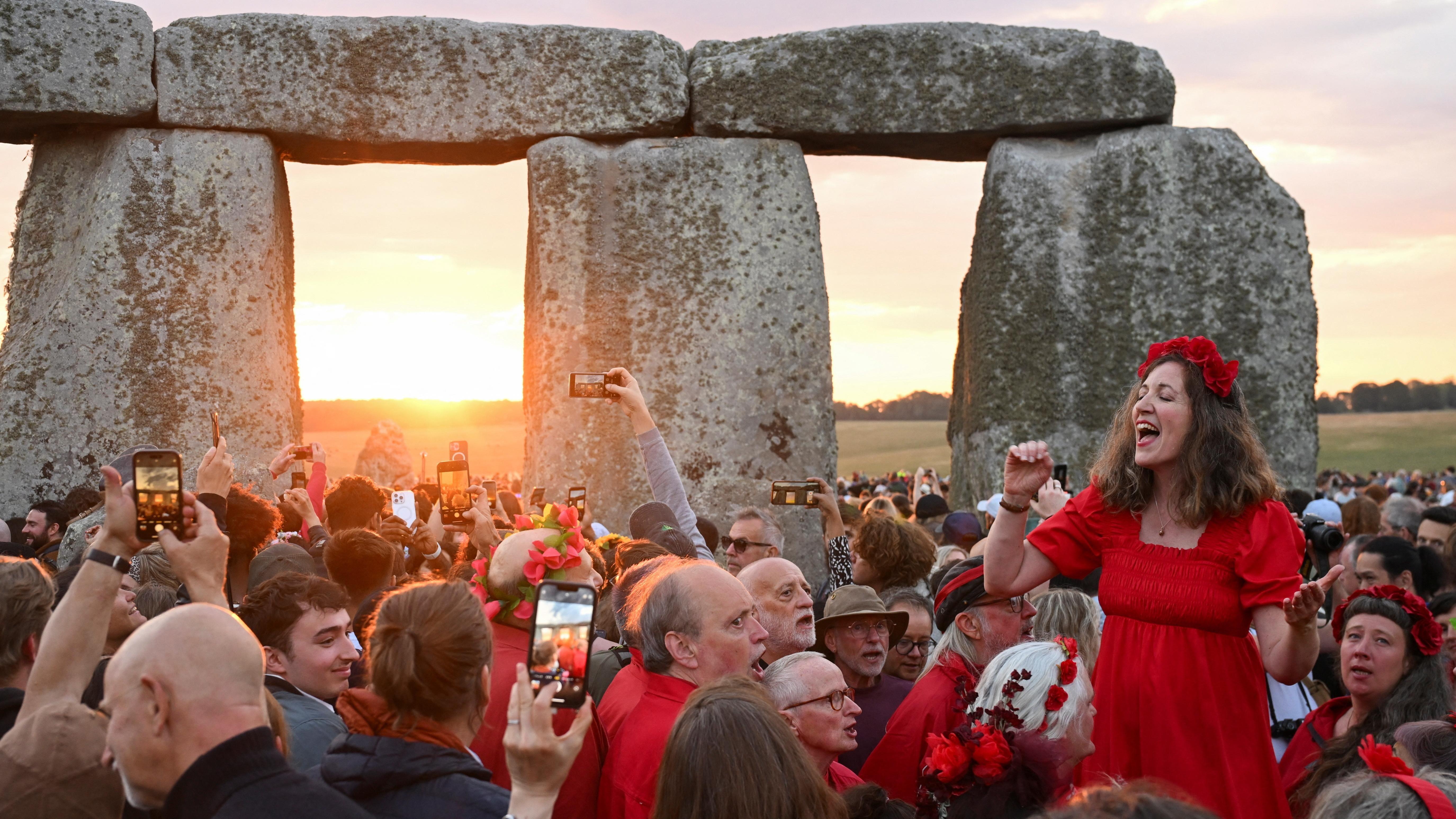 Thousands celebrate solstice at Stonehenge as UK faces 34C heat on longest day of year 