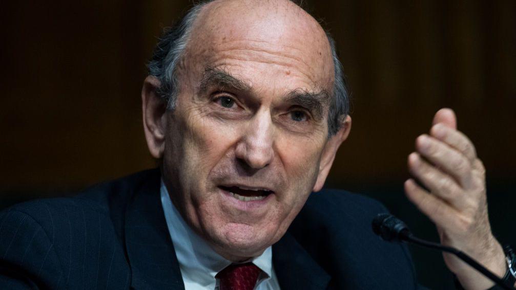 Elliott Abrams habla y gesticula con su mano izquierda. 