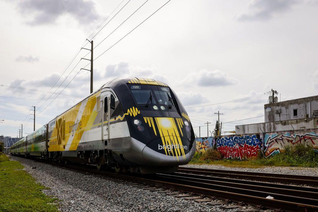 Un tren Brightline pasa junto a un muro con pintadas en la ciudad de Miami.