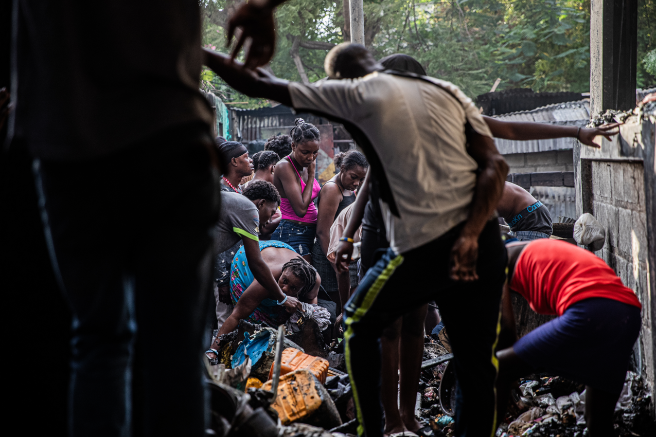 Gente busca entre lo que queda tras el incendio en un campo de desplazados en Puerto Príncipe, Haití, el 21 de diciembre de 2025. 
