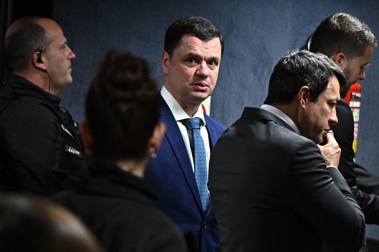 Anderson Torres com olhar assustado, rodeado por outras pessoas em sala do STF 