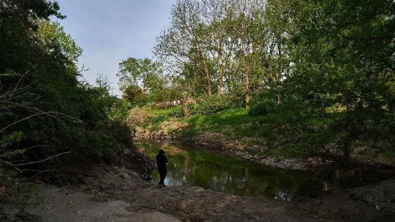 Una figura solitaria encapuchada se encuentra a orillas del arroyo Coldwater.