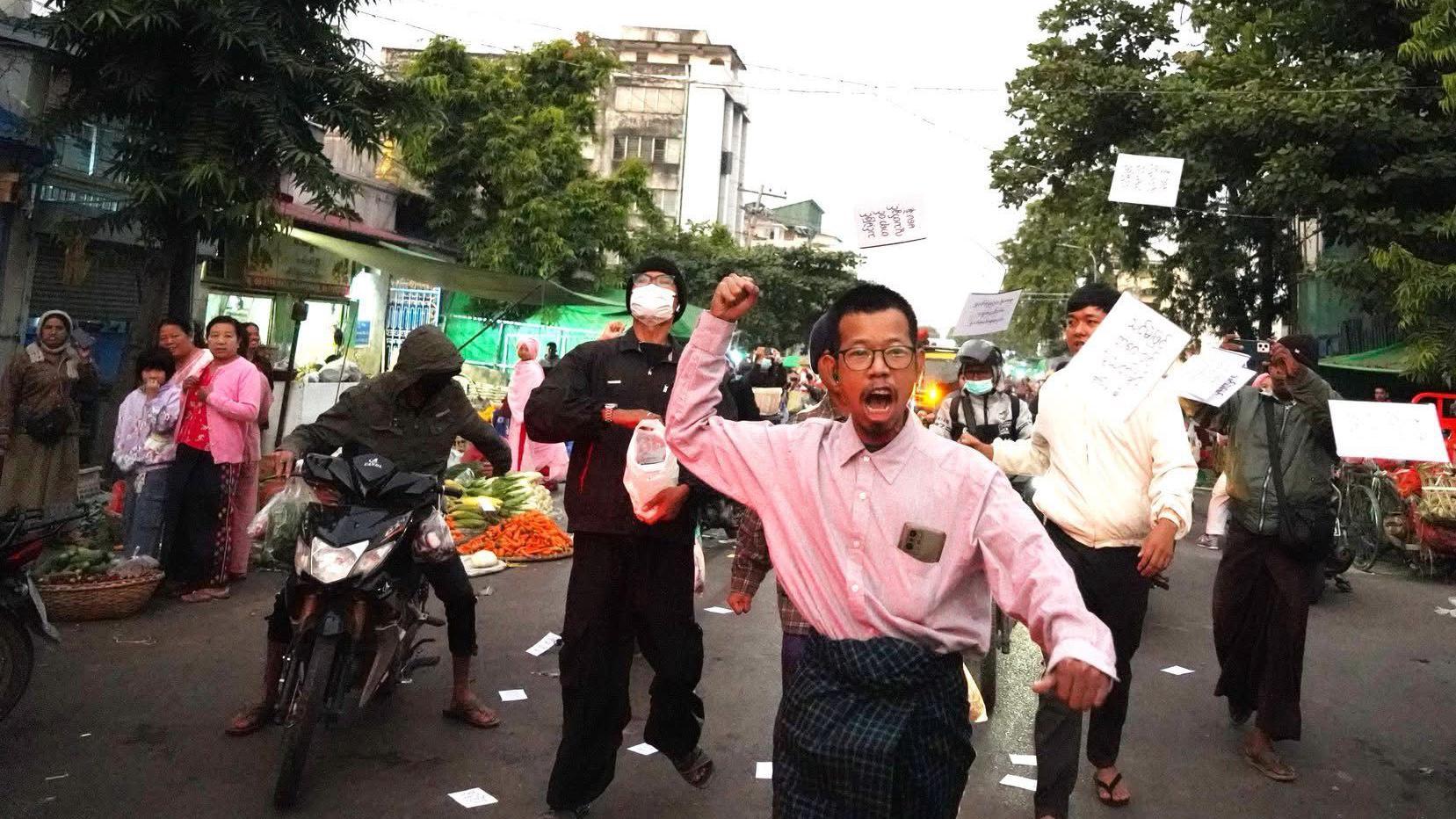 泰扎山與其他人一起在繁忙街道上散發呼籲抵制選舉的傳單