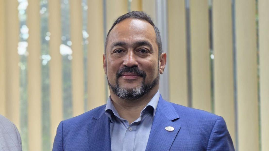 José Sousa-Santos: um homem de cavanhaque vestindo terno azul e camisa azul  
