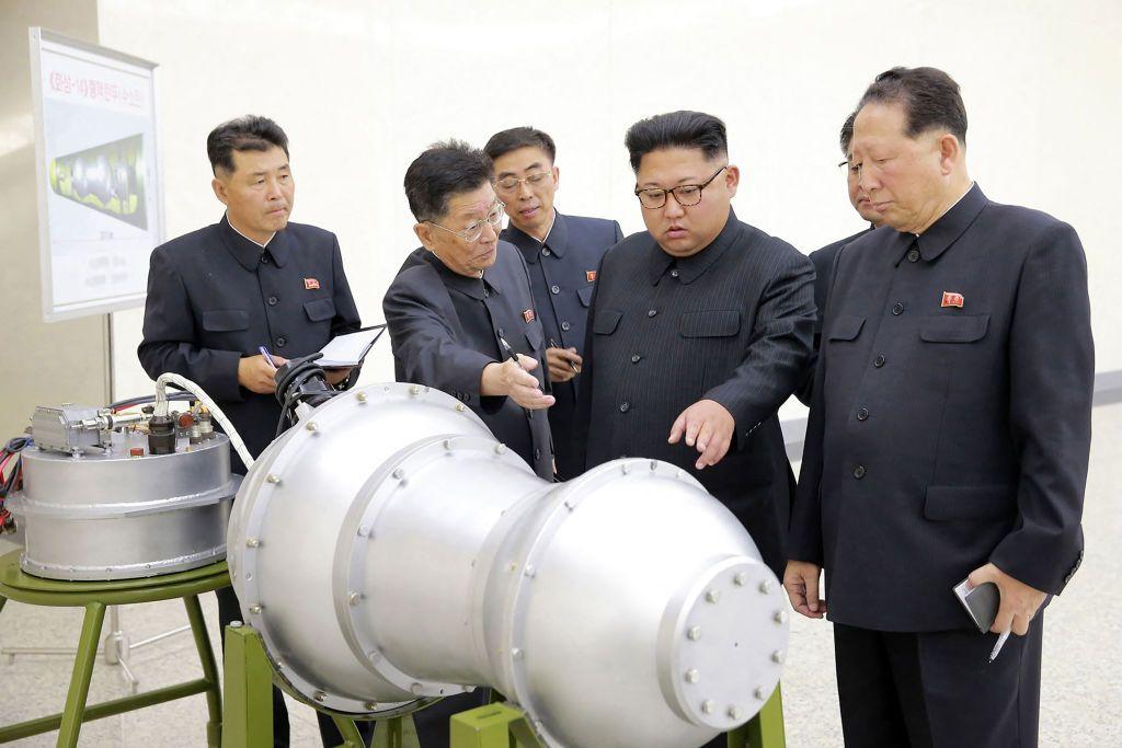 Kim Jong Un,  rodeado de cinco funcionarios norcoreanos observan el revestimiento metálico de lo que aparenta ser una bomba