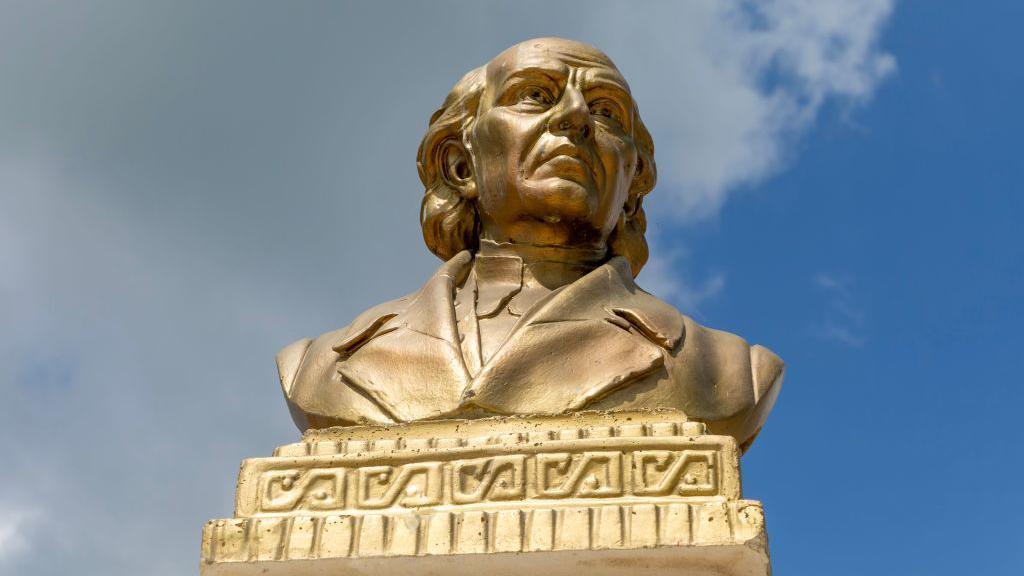 Busto en color oro de Miguel Hidalgo.