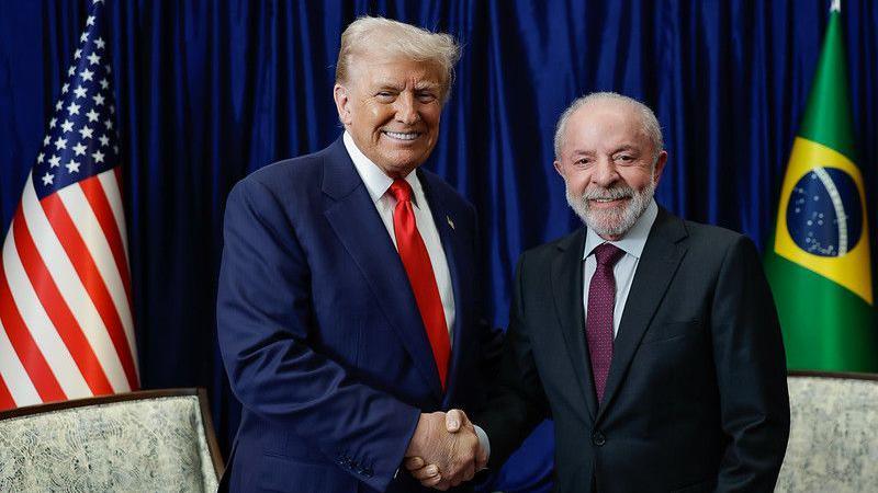 Trump e Lula (à direita) se cumprimentam 