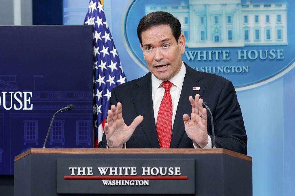 El secretario de Estado de EE.UU., Marco Rubio, parado ante un atril de la Casa Blanca, con un traje negro y corbata roja
