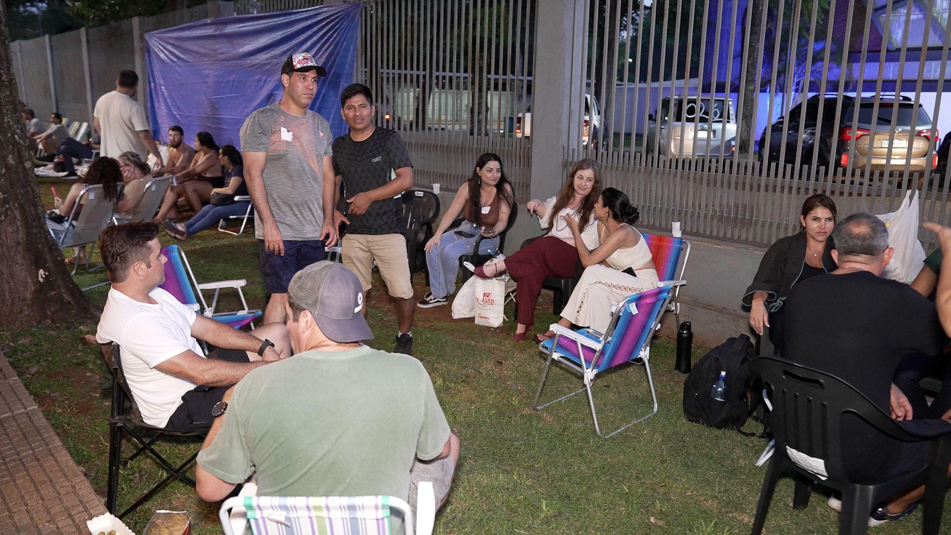 PEssoas sentadas em cadeira na fila