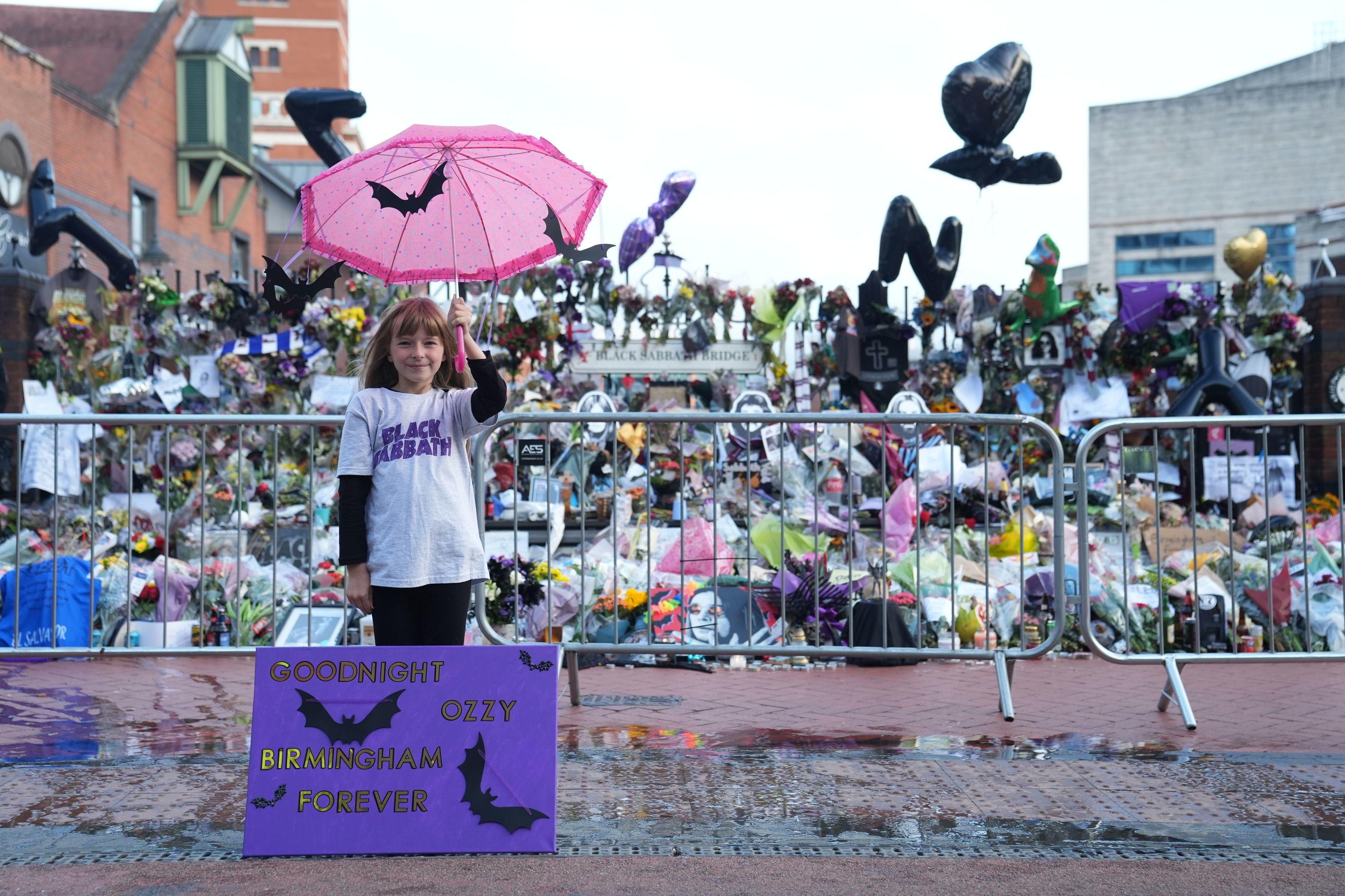 Eliza Finn-O'shea, de 10 años, posa junto a un cartel con murciélagos en el que recuerda a Ozzy Osbourne