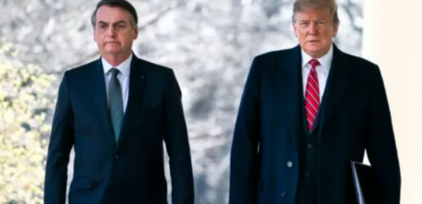 Foto com Bolsonaro à esquerda e Donald Trump à direita ambos usando terno e sobretudo