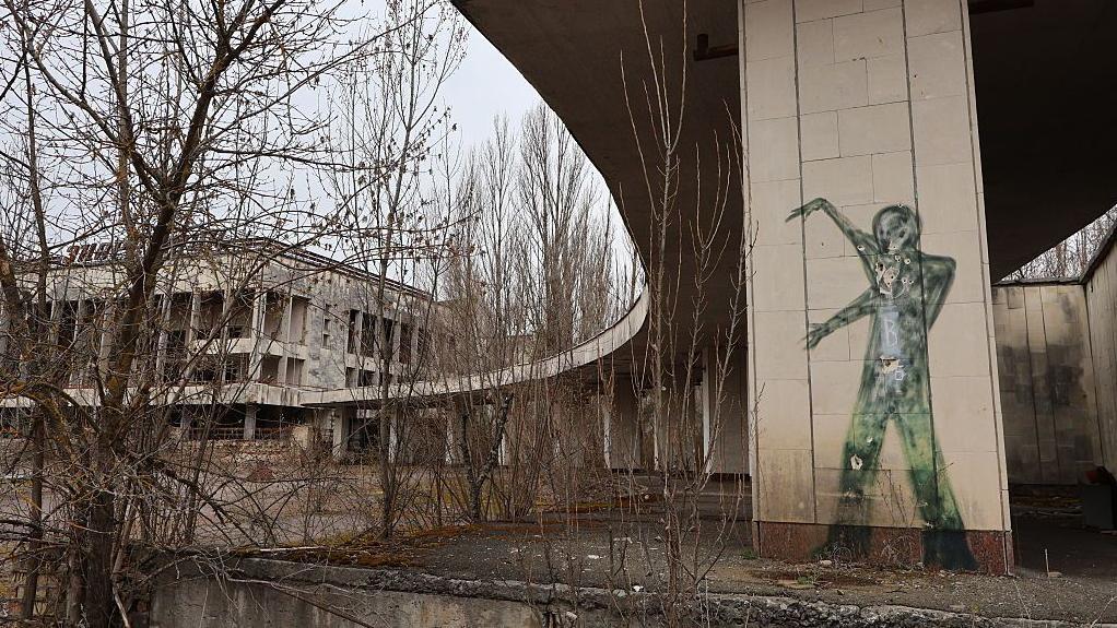 Grafites no Palácio da Cultura Enerhetyk, abandonado na praça central de Prypiat, no oblast de Kiev, na Ucrânia, em 12 de abril de 2025