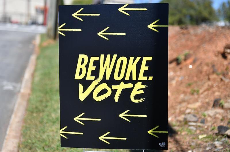 letrero que dice "sé woke. vota".