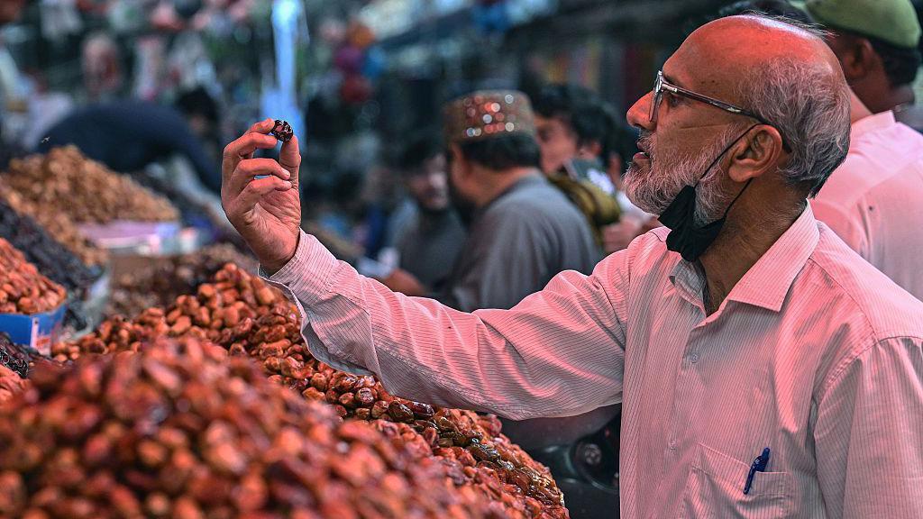 ایک شخص کھجور کا معائنہ کر رہا ہے