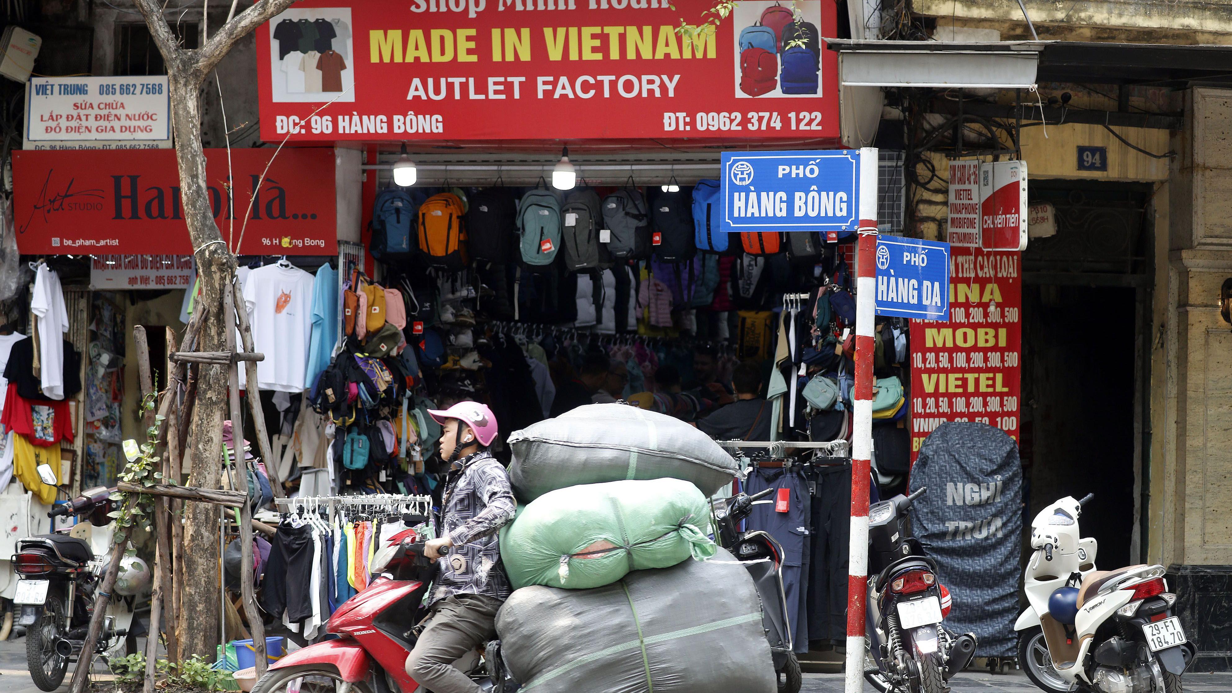 Toko 'Made in Vietnam' dan pengendara motor di Hanoi, Vietnam, 03 April 2025.