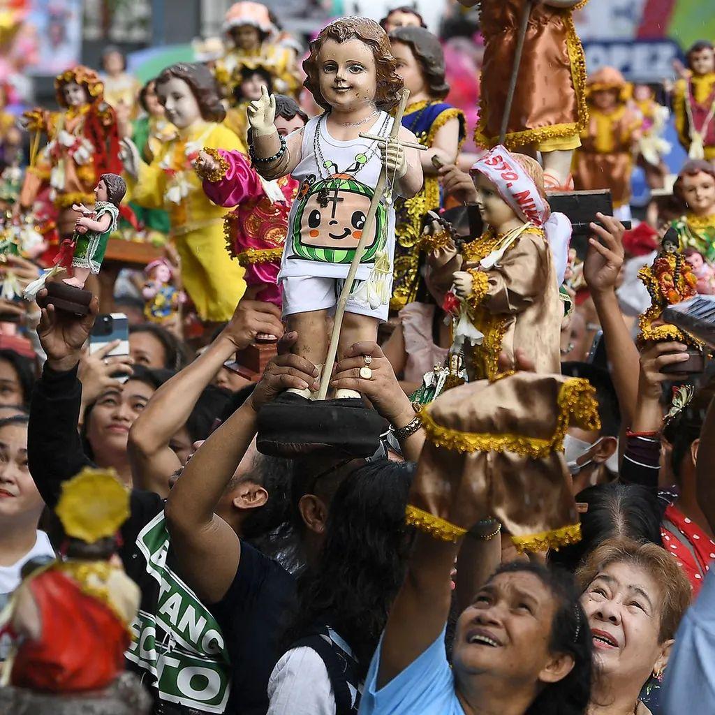 Pessoas em Manila segurando imagens do Menino Jesus, &iacute;cone introduzido nas Filipinas por Magalh&atilde;es