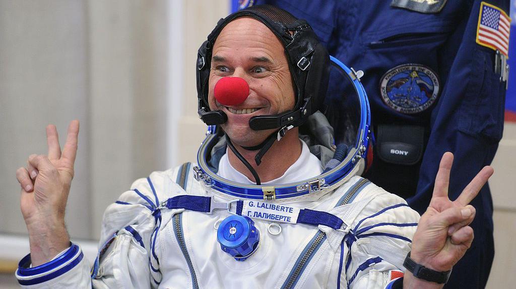 Guy Lalibert&eacute;, turista espacial canadense e fundador do Cirque du Soleil, usa nariz vermelho de palha&ccedil;o e faz o sinal de &ldquo;V&rdquo; durante testes do traje espacial antes de seu lan&ccedil;amento, em 2009, rumo &agrave; Esta&ccedil;&atilde;o Espacial Internacional