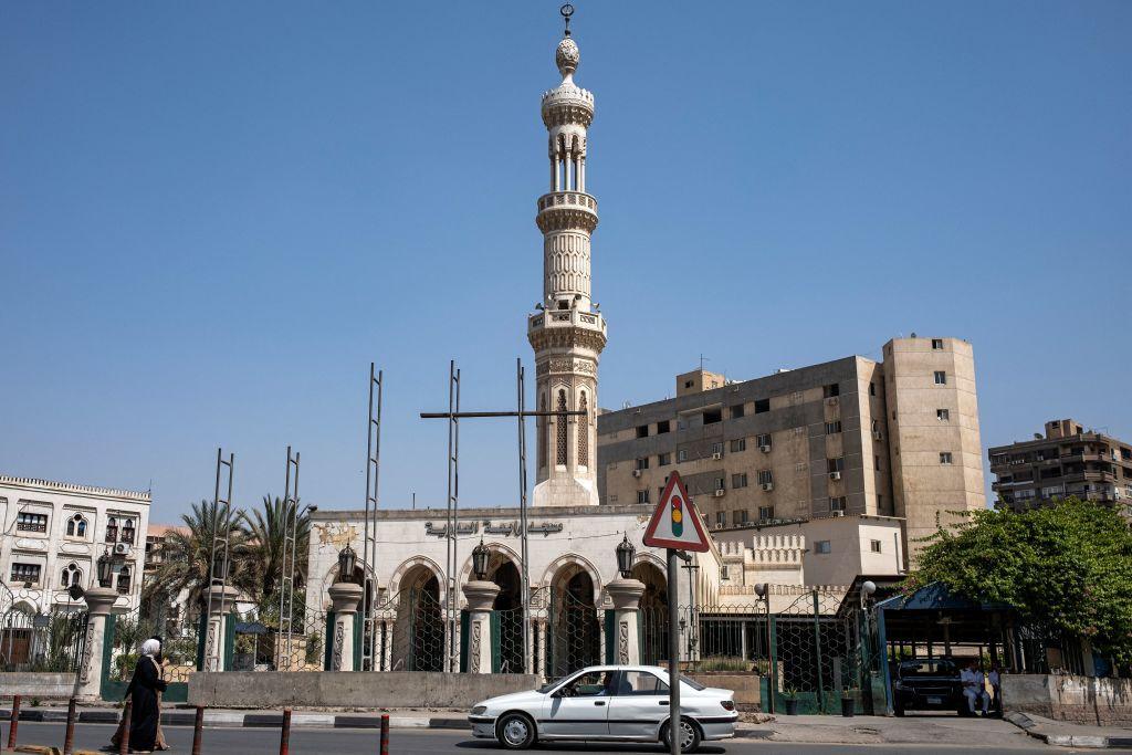 تعبر امرأتان شارعًا بينما تمر سيارة أمام مسجد رابعة العدوية في مدينة نصر بالقاهرة، الذي كان مركزًا لحركة اعتصام الإخوان المسلمين احتجاجًا على الإطاحة بالرئيس الإسلامي محمد مرسي عام 2013.