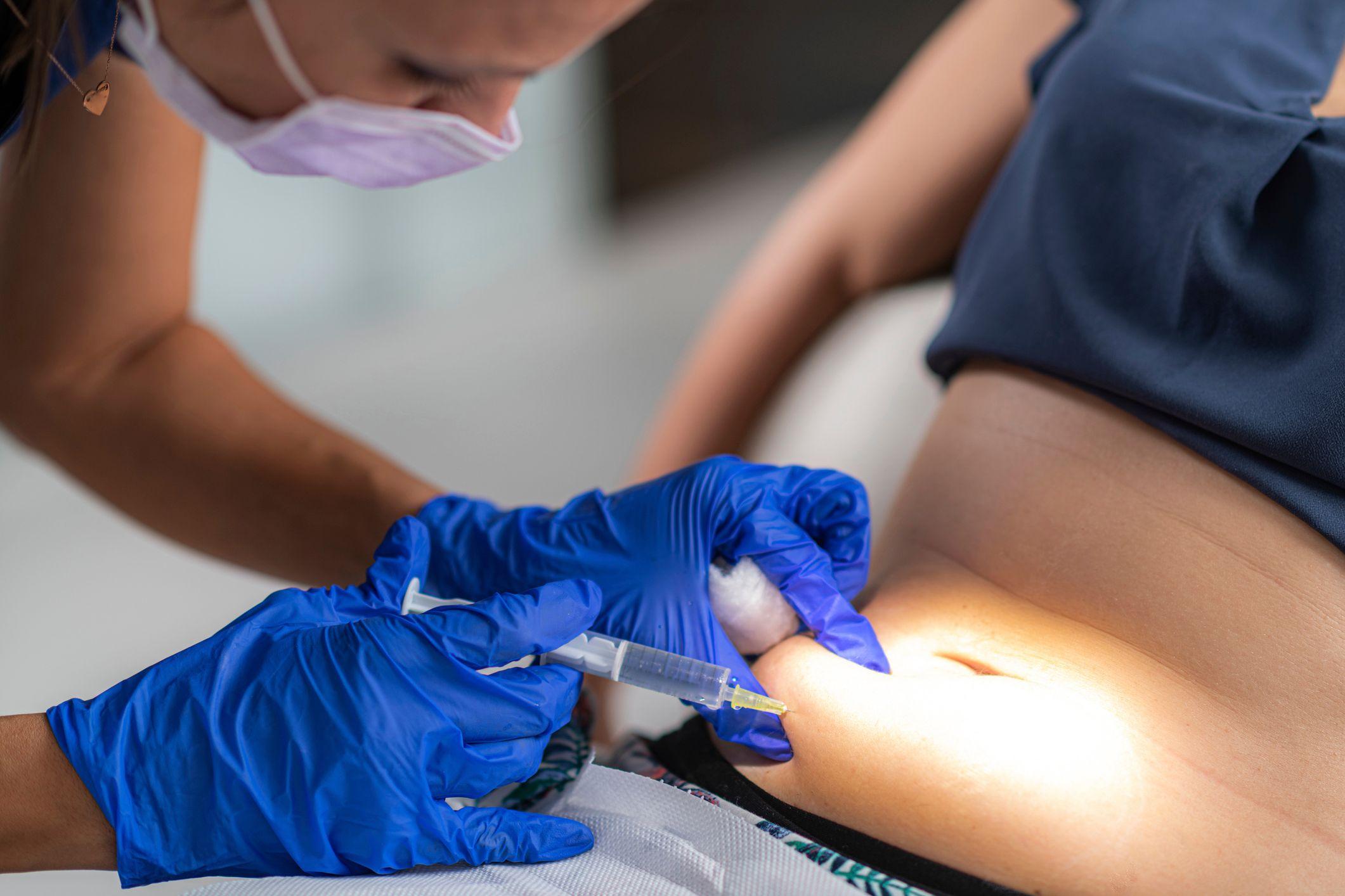 Una persona recibiendo una inyección en el abdomen