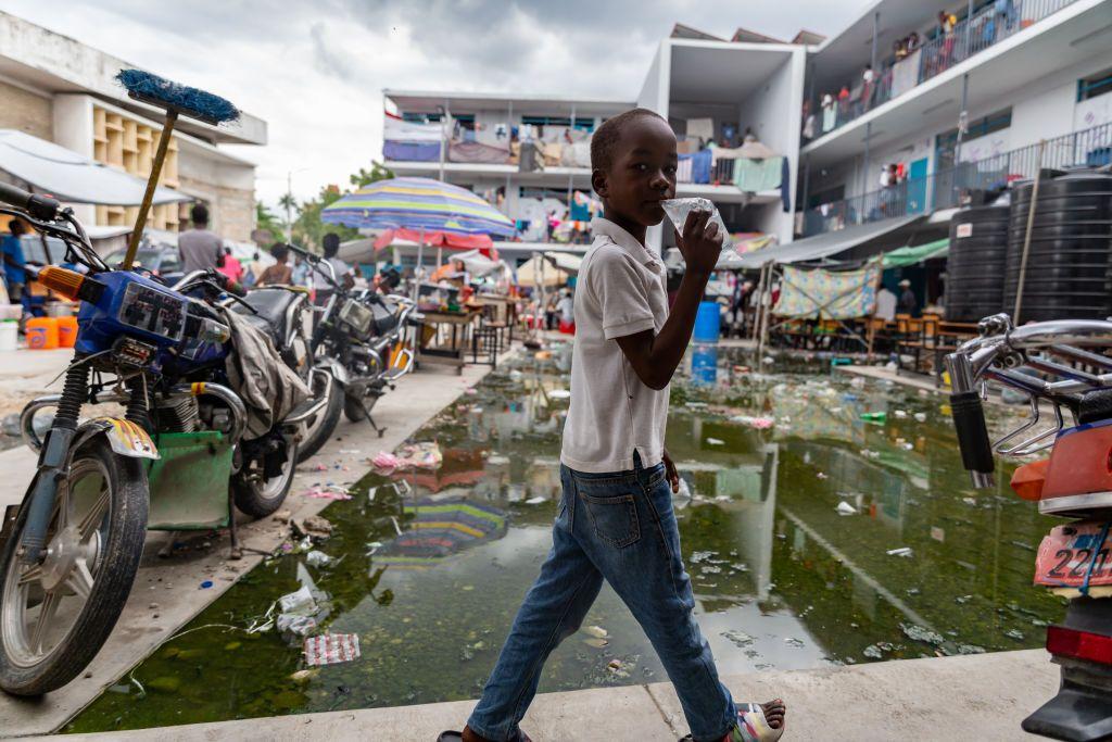 Uma crian&ccedil;a caminha pelo p&aacute;tio de um campo de refugiados em Porto Pr&iacute;ncipe, no Haiti, para onde milhares de pessoas fugiram ap&oacute;s serem for&ccedil;adas a deixar suas casas devido &agrave; viol&ecirc;ncia de gangues, em meio &agrave; falta de abrigo, comida, &aacute;gua pot&aacute;vel e servi&ccedil;os b&aacute;sicos.