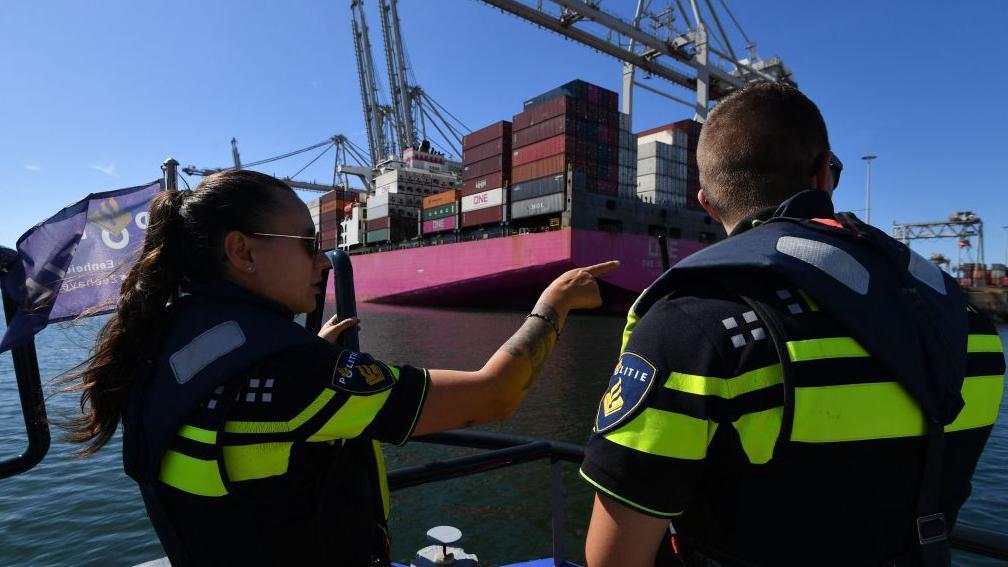 Policías holandeses cerca de un barco de carga