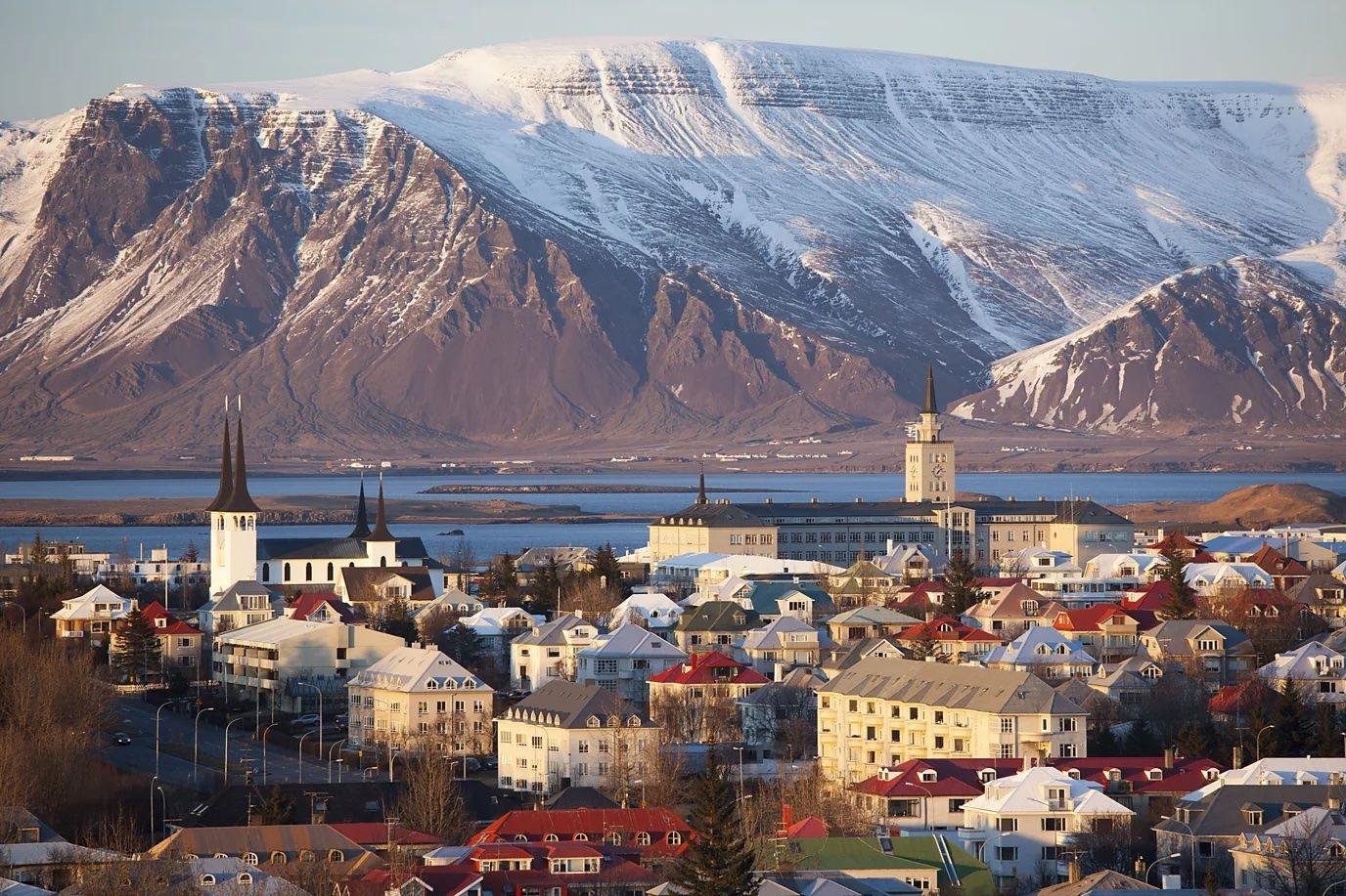 Una panorámica de una ciudad de Islandia, con un increíble atardecer y una montaña congelada en el fondo.