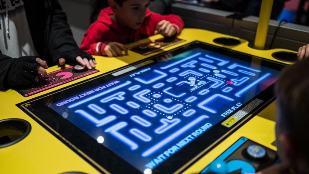pantalla de juego de mesa grande con niños jugando pac-mac