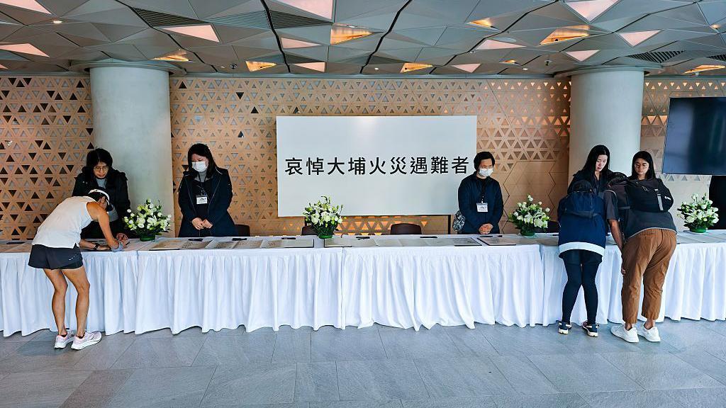 2025年11月29日，在香港大埔區，人們來到弔唁點悼念罹難者。