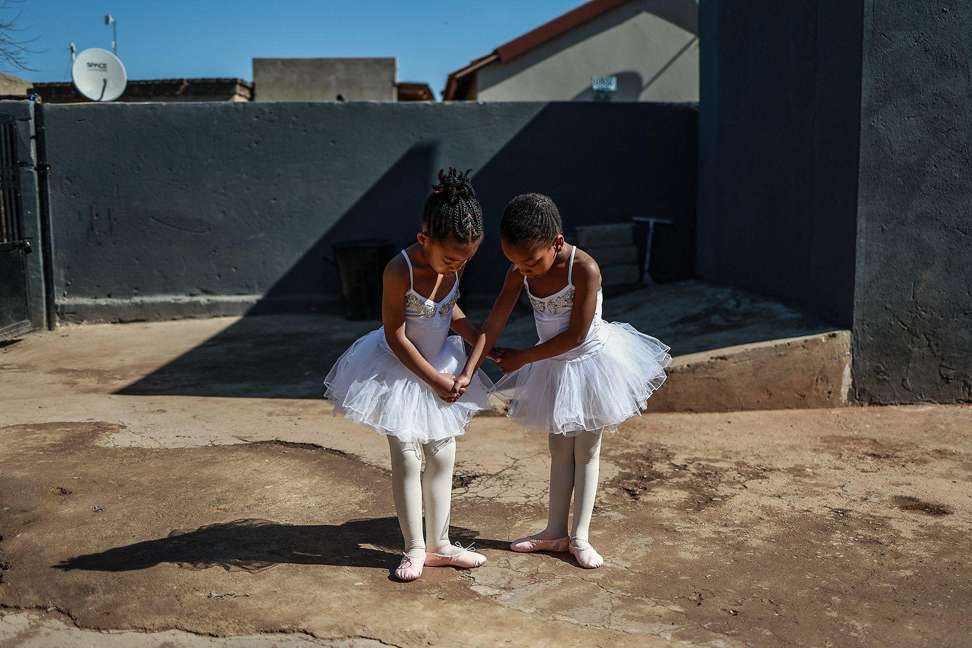 Dos niñas bailarinas preparan sus poses de ballet.