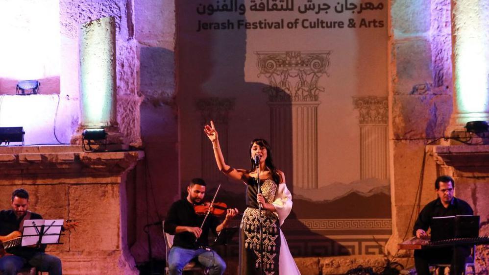مهرجان طعام وآخر فني يثيران الجدل في الأردن لتزامنهما مع "الجوع في غزة"، فما القصة؟ 1 المغنية السورية فايا يونان تقدم حفلاً موسيقياً في مهرجان جرش للثقافة والفنون في 30 يوليو 2022، في مدينة جرش اليونانية الرومانية القديمة، شمال العاصمة الأردنية عمّان.