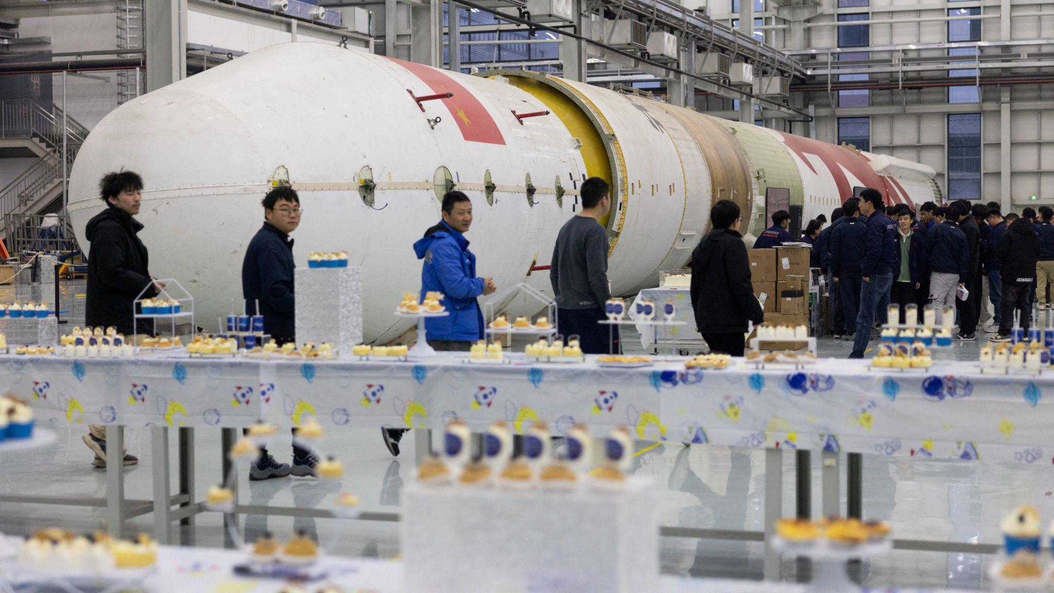 藍箭航天浙江湖州工廠內職工集合參與聚會，背景為朱雀二號火箭（17/12/2025）