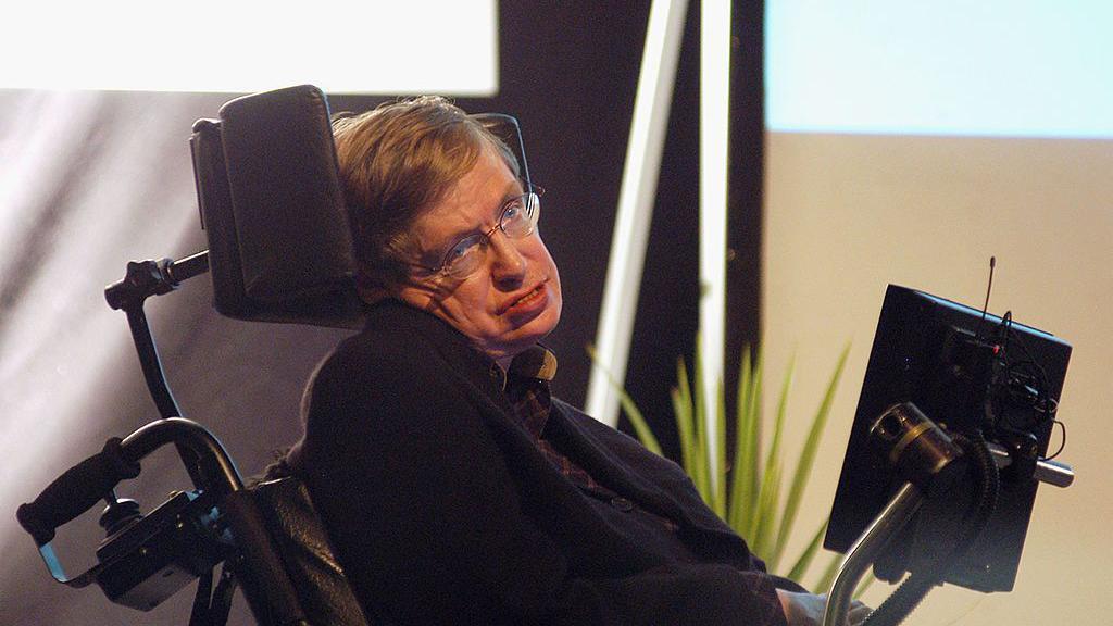 imagen de Stephen Hawking en una silla de ruedas con su aparato de comunicación. 