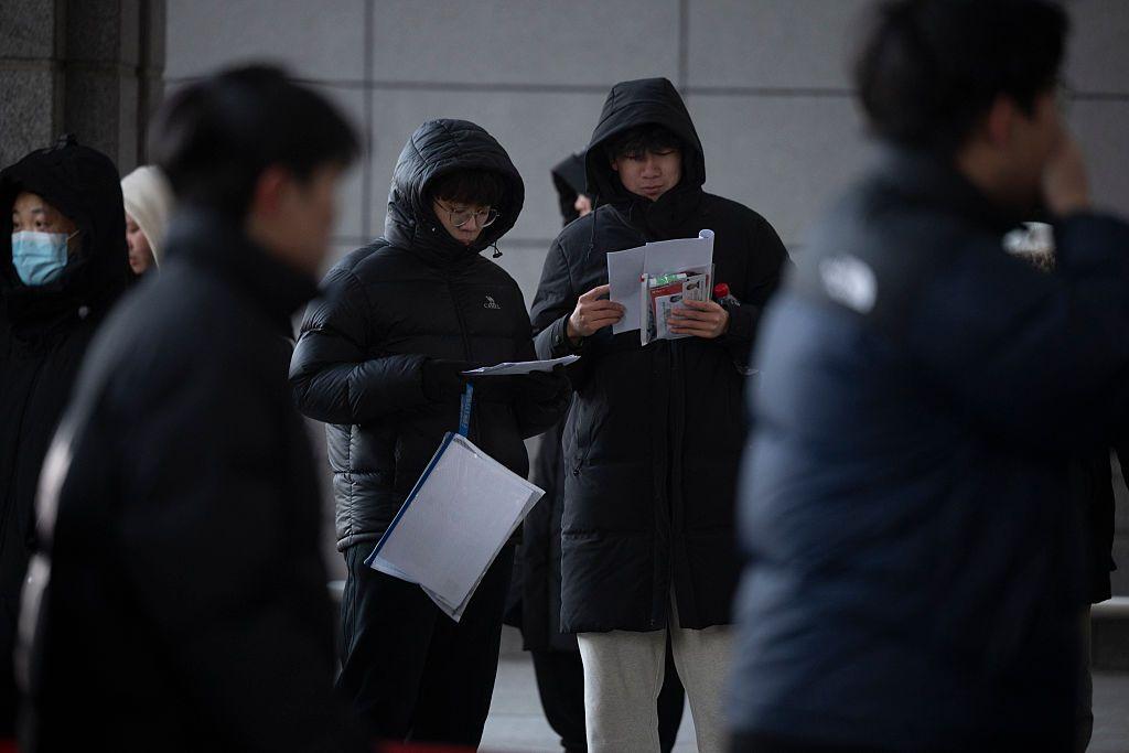 幾個身著棉服的男生正在閱讀