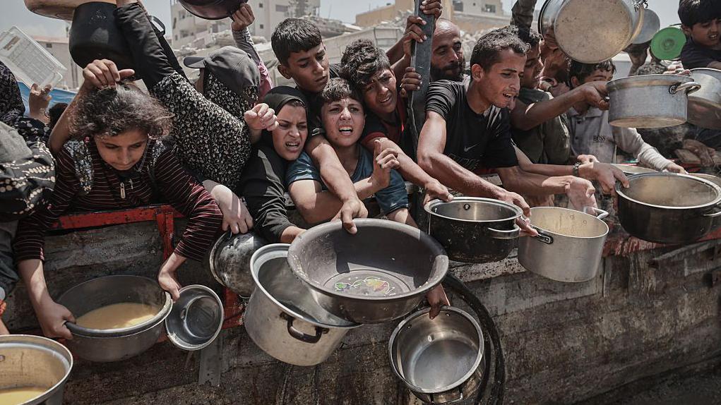 Pessoas segurando panelas vazias