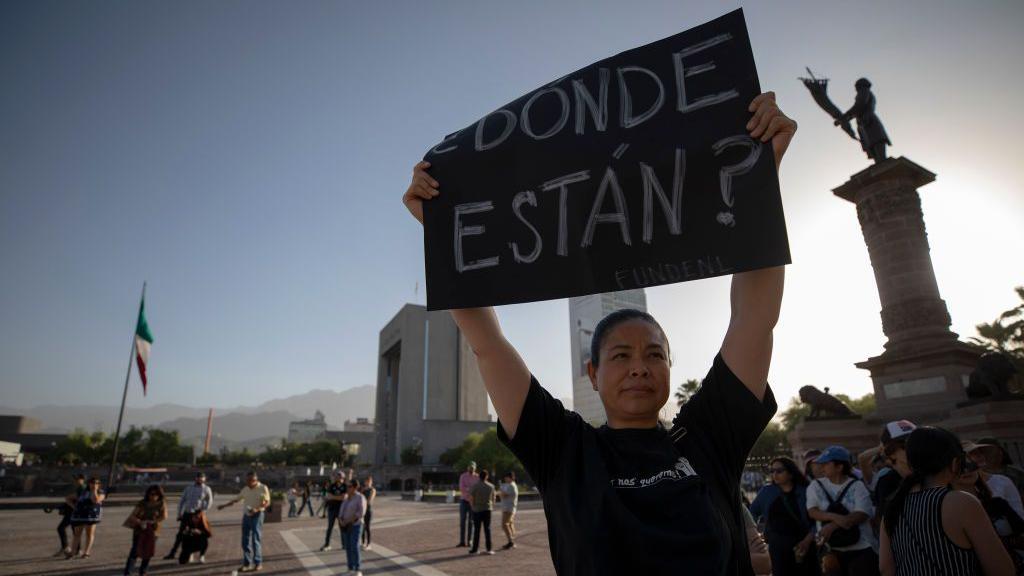 Mulher sustenta um cartaz que pergunta: 'Onde estão?'