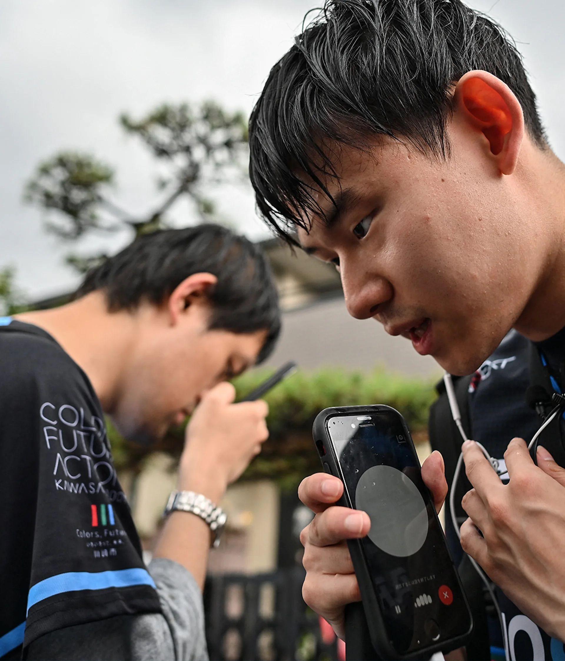 兩名視障人士拿著手機，與程式對話