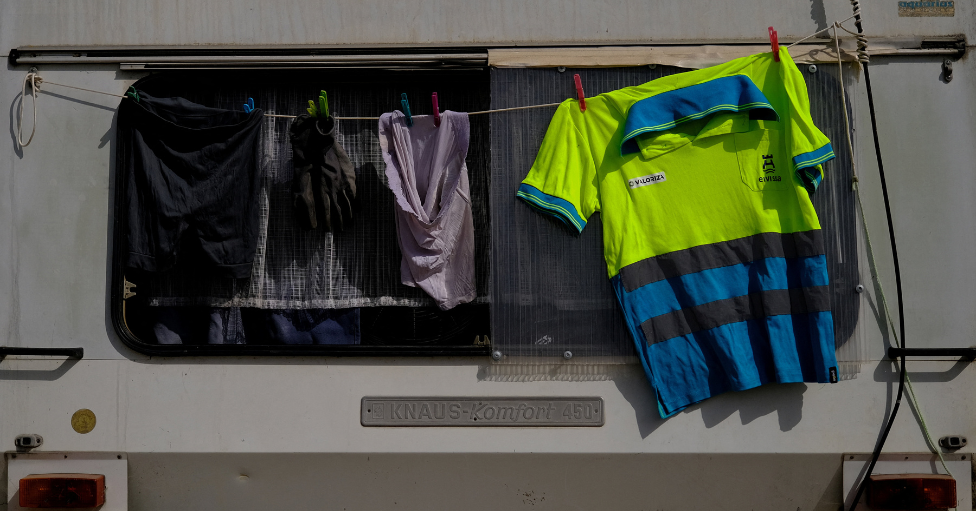 Ropa de trabajo tendida junto a una autocaravana en Ibiza, España. 