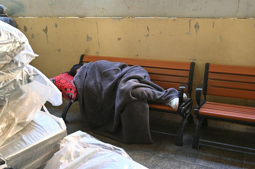 شابٌّ من عائلةٍ نزحت، يغفو على مقعدٍ في مدرسةٍ تحوّلت إلى ملجأٍ في بيروت، في 9 مارس/آذار 2026. 