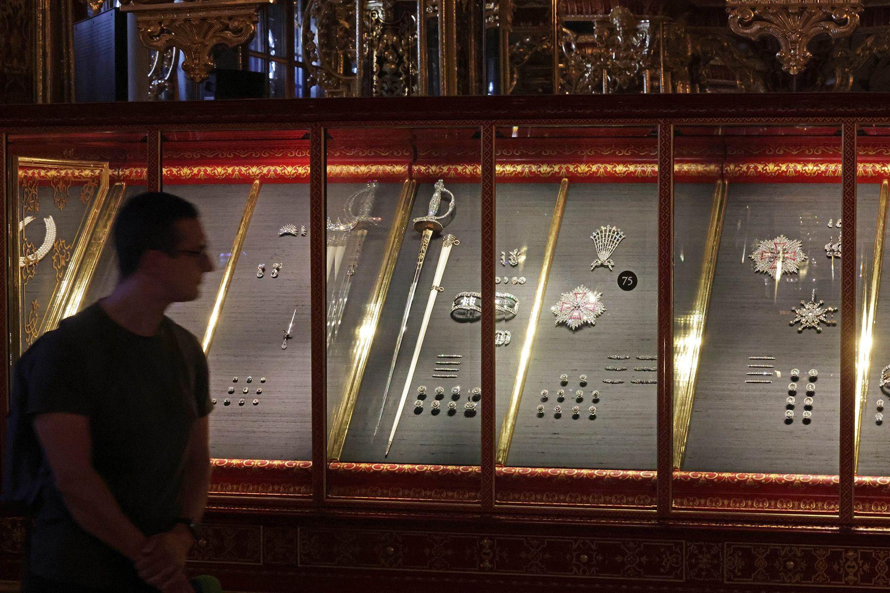 Una exhibición de una colección de artefactos históricos de intrincada elaboración del museo de la Bóveda Verde, que incluye espadas, joyas decorativas y otros objetos ornamentales.