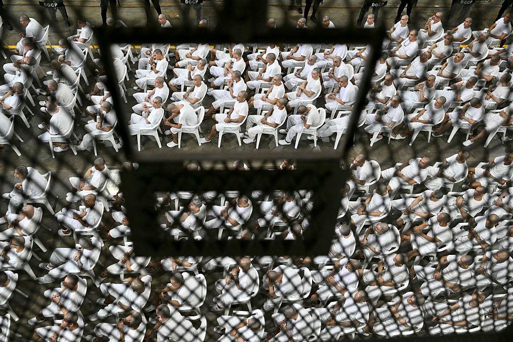 Presos en el Cecot, El Salvador, sentados en filas detrás de rejas durante una audiencia judicial remota en abril de 2026.