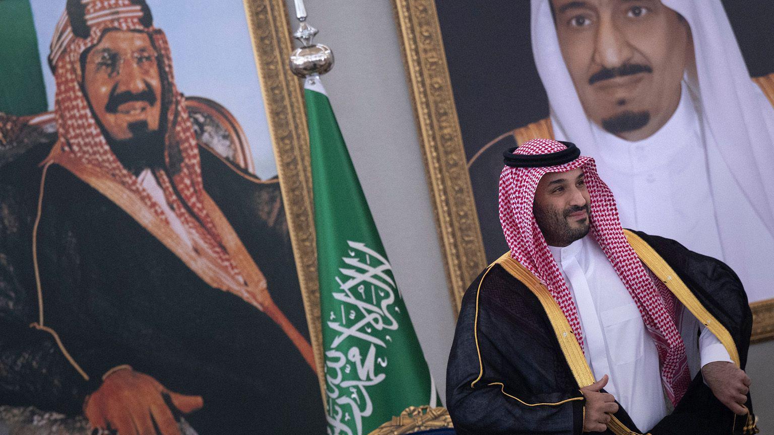 محمد بن سلمان أمام صور كبيرة.