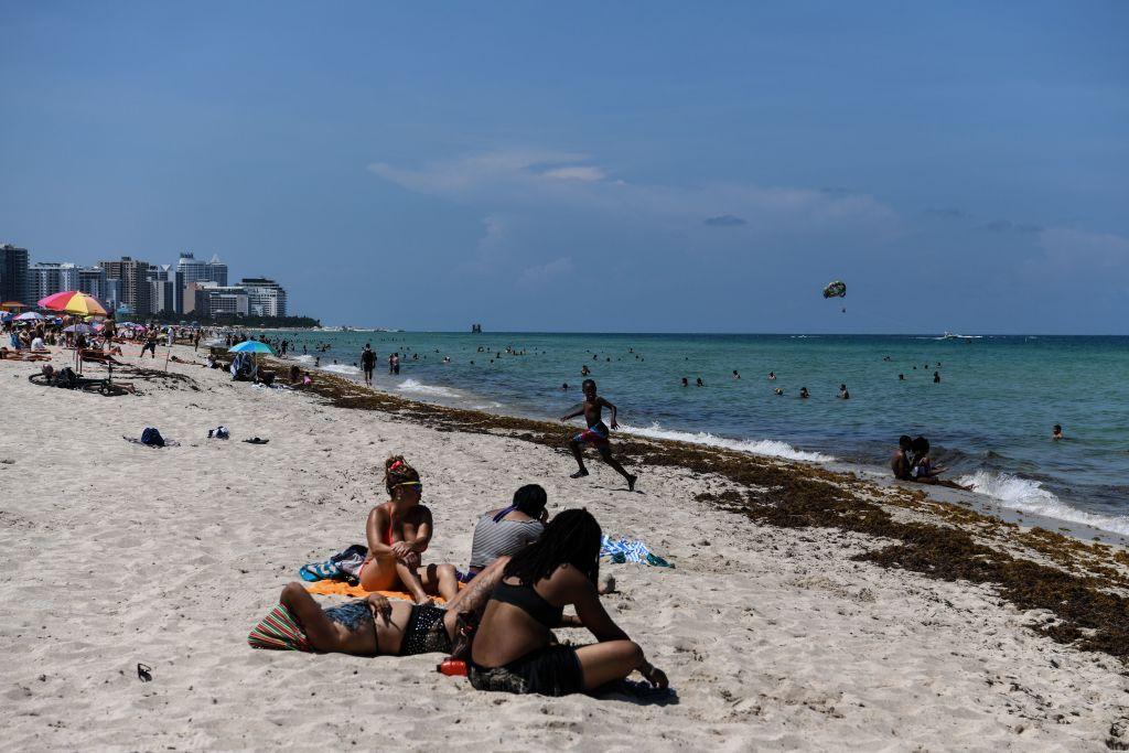 Personas disfrutan de las playas el primer día que reabrieron, en junio de 2020.