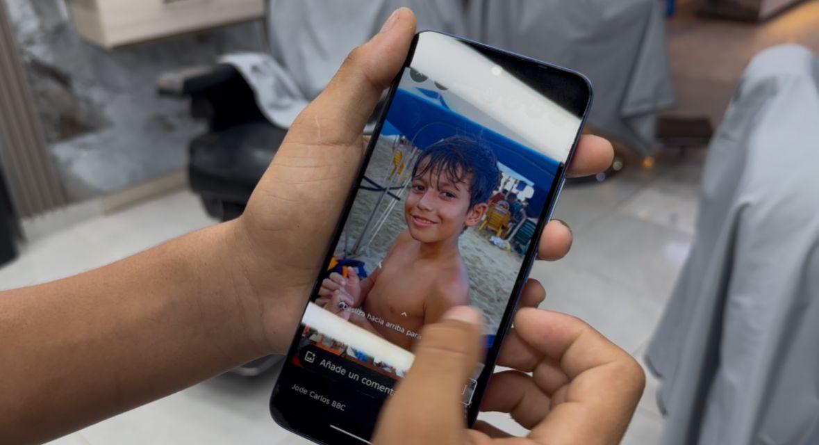 Deivi muestra una foto de su hermano menor en un celular